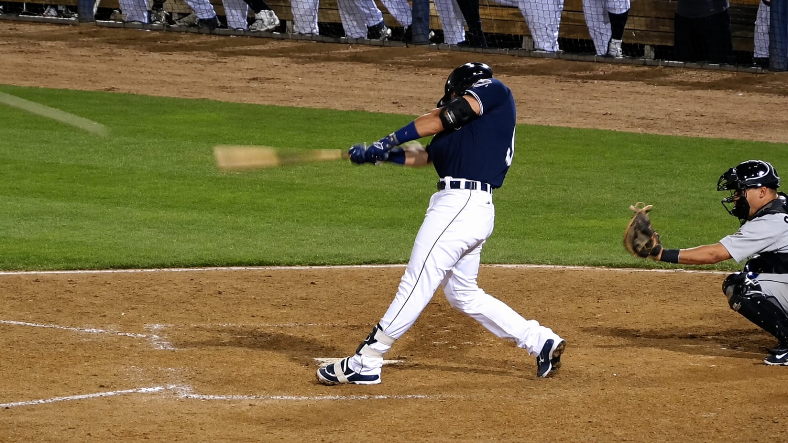 Professional baseball pitcher in mid-windup under stadium lights